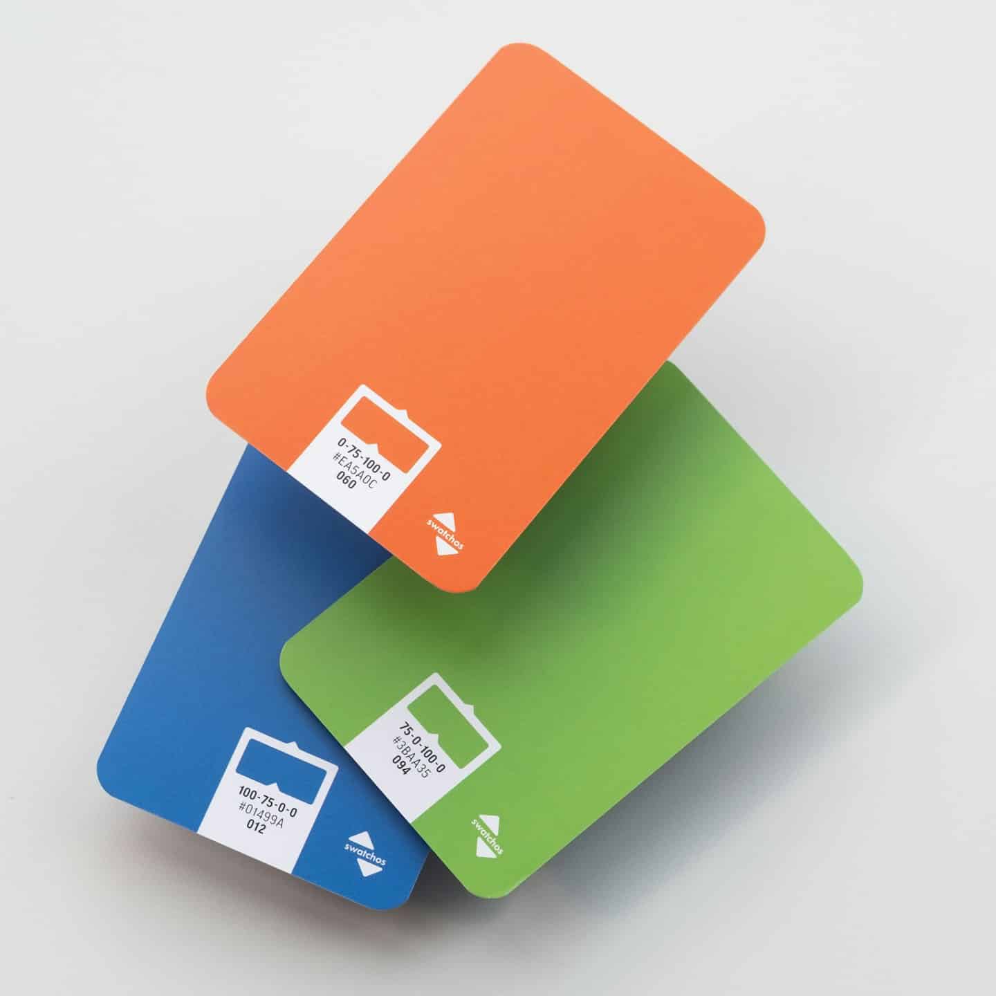 Tre carte campione di colore impilate che mostrano codici CMYK ed esadecimali.